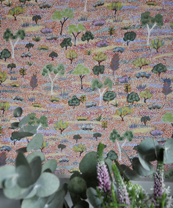 Aboriginal art wallpaper detail with Eucalyptus and flowers in the foreground.