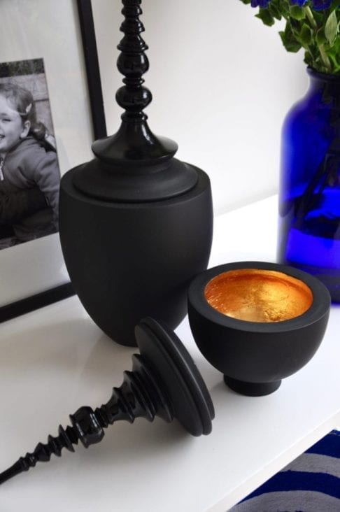 Matt and gloss black decorative lidded pots in two sizes.