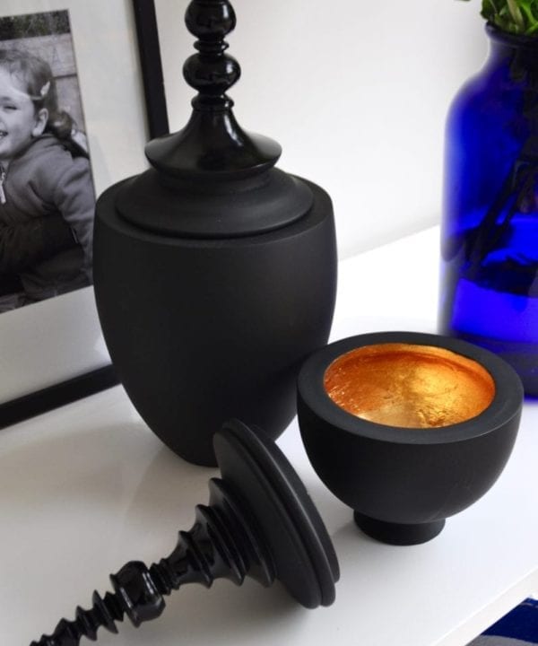 Matt and gloss black decorative lidded pots in two sizes.