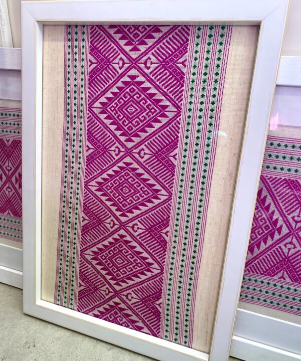 A smaller, portrait framed Thai textile pink wall art adds colour and culture.