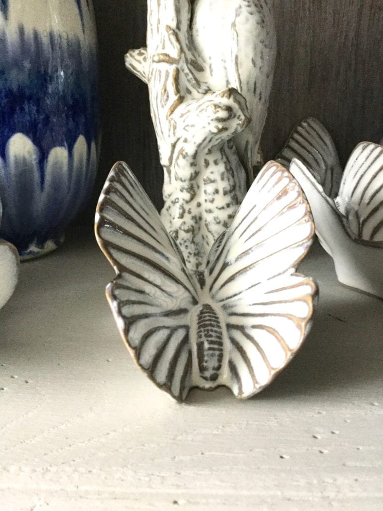 Decorative butterfly wall art in glazed white ceramic.