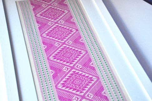 Traditional Thai woven motifs in hot pink and green framed in white for wall art.