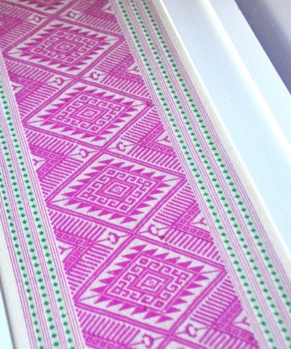 Traditional Thai woven motifs in hot pink and green framed in white for wall art.