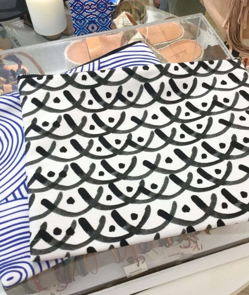 Prints of hand-painted, monochrome pattern on cotton clutch bags in a Paxos boutique.