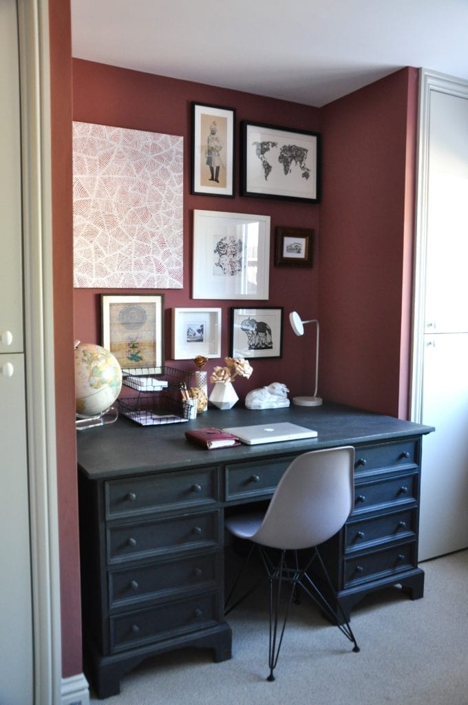 A smart, study area niche with a black-painted desk flanked by built-in cupboards either side.