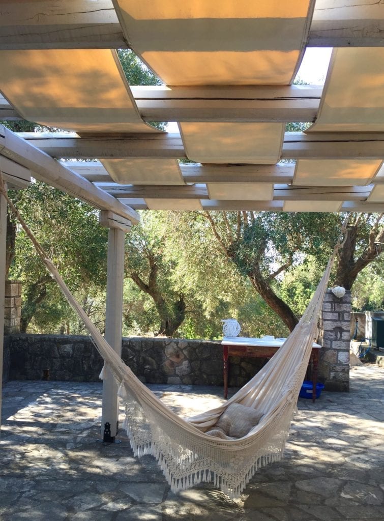 A hammock on a terrace at an old stone cottage in the olive groves on the Greek island of Paxos.