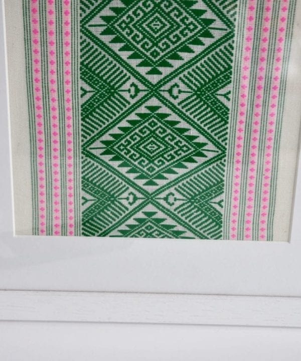 A simple white frame elevates this culturally-inspired, hand-woven Thai textile in green and baby pink.