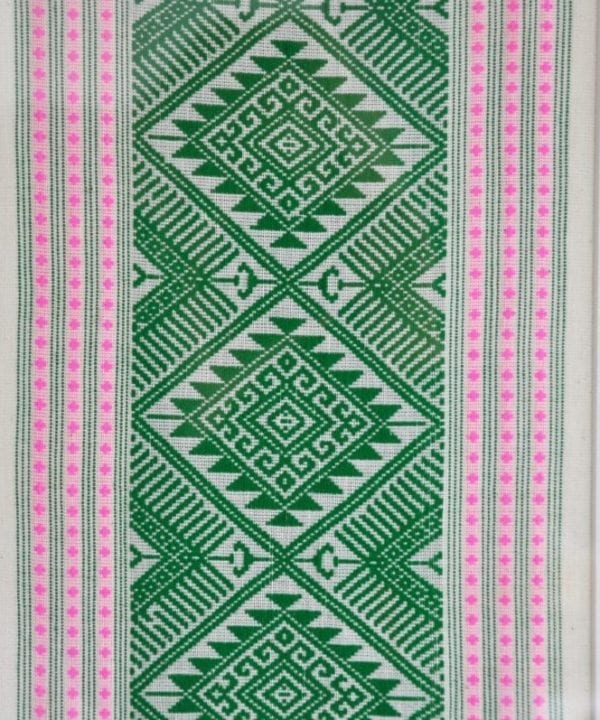 Detail of a framed textile wall art piece in pea green with candy pink accents. The textile was hand-loomed in northern Thailand.