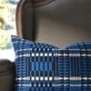 A blue geometric cushion with an African, tribal-pattern-inspired design on a French armchair.