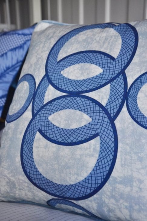 A blue African circles print cushion close-up image.