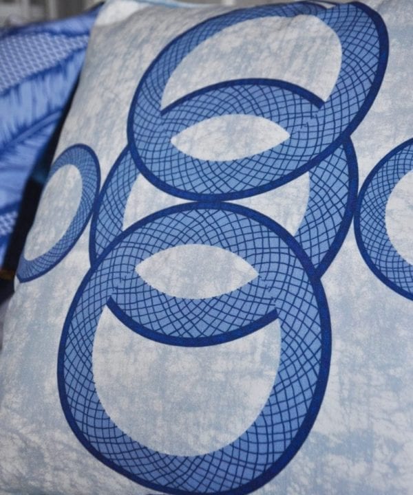 A blue African circles print cushion close-up image.