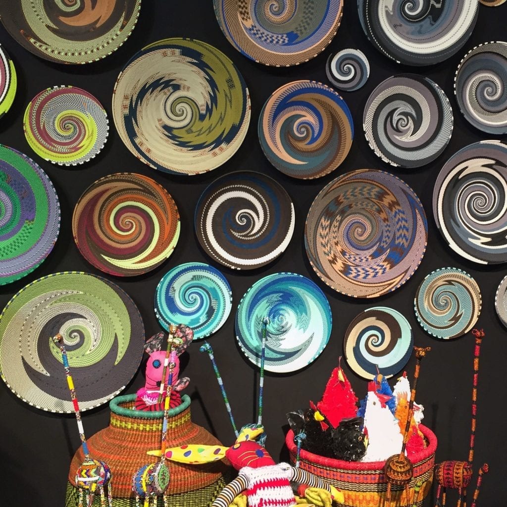 A wall display of colourful African, telephone wire baskets.