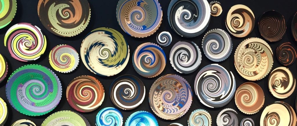 Multi-coloured African telephone wire bowls as wall art.