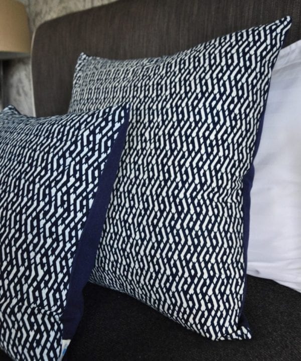 Indigo cushions with Eastern styling dressing a bed.