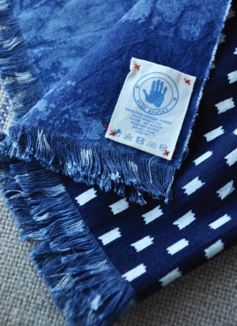 Shot of an indigo blue check scarf showing the Blue Handed label.