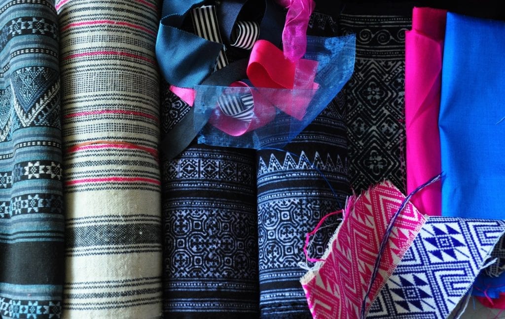 A collection of pink and indigo Thai textiles and ribbons.