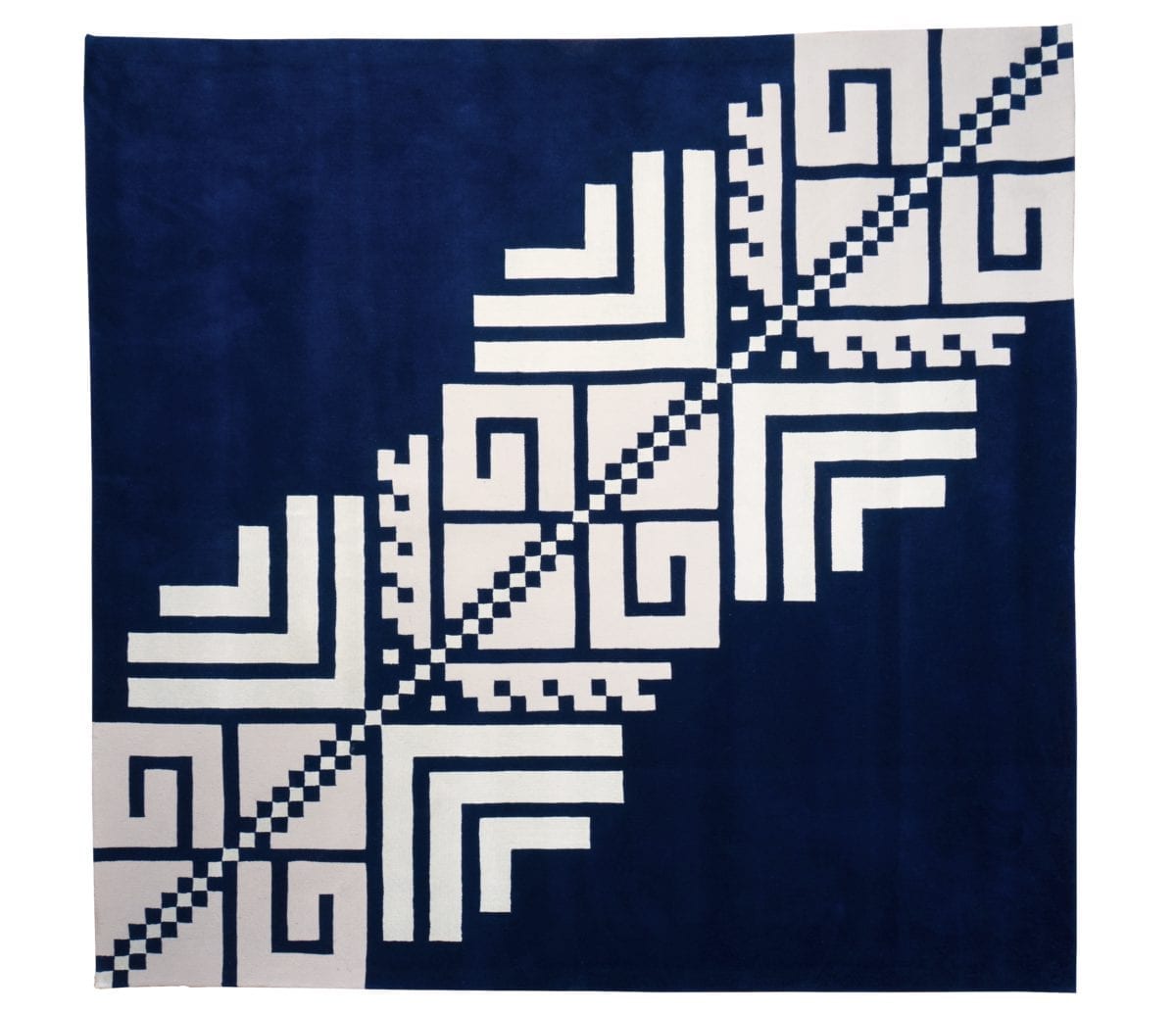 Overhead shot of a Romanian folk pattern rug in navy and white.