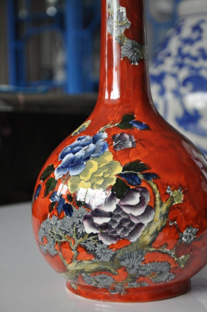 A decorative, Chinese style, bottle vase in orange, yellow and blue with floral décor.