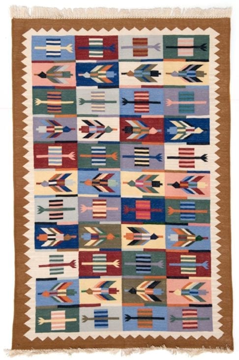 A multi-coloured, flèche-motif, Aztec style rug.