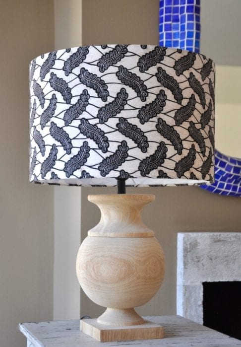 A stylish monochrome drum lampshade available in two sizes teamed with a simple, urn-shaped wooden base.