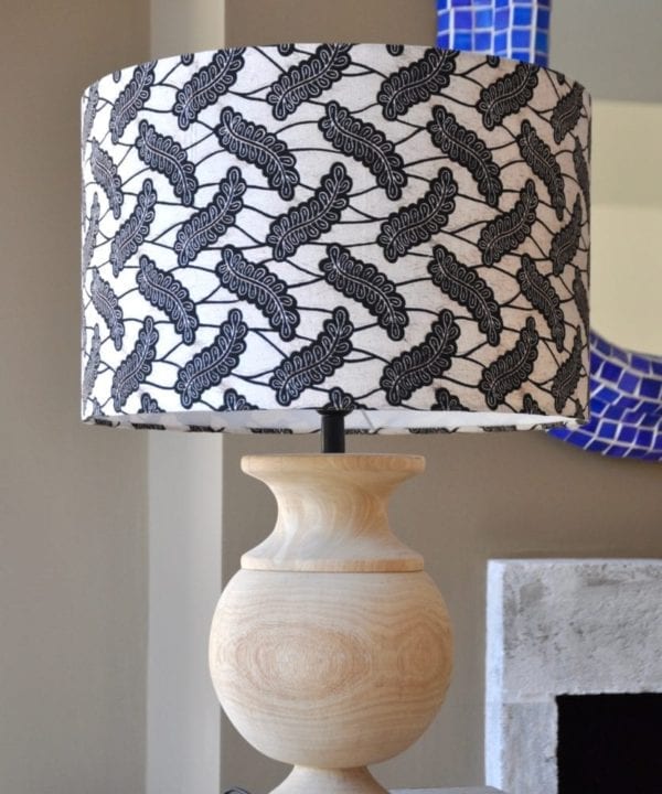 A stylish monochrome drum lampshade available in two sizes teamed with a simple, urn-shaped wooden base.