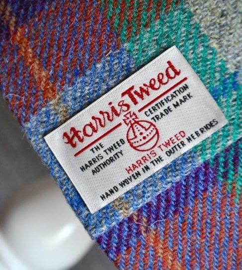 A close-up detail of the Harris Tweed Authority's Orb label of authenticity on a check drum shade available through Telescope Style.