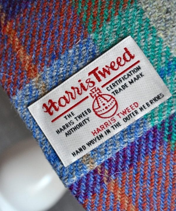 A close-up detail of the Harris Tweed Authority's Orb label of authenticity on a check drum shade available through Telescope Style.