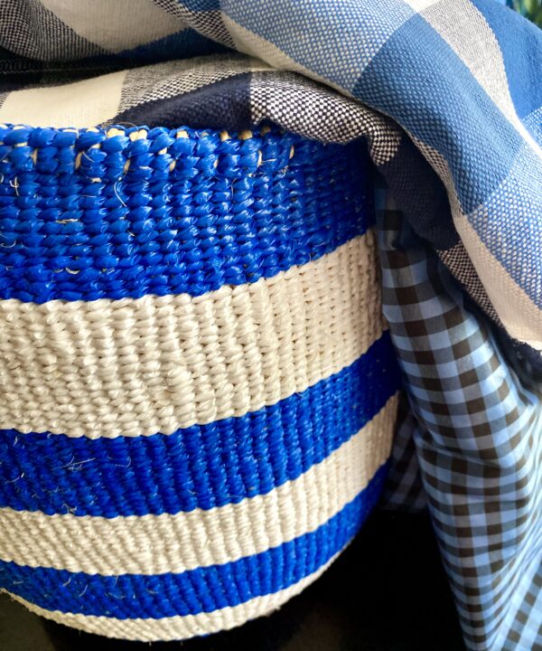 A vibrant, blue and white striped, woven storage basket.