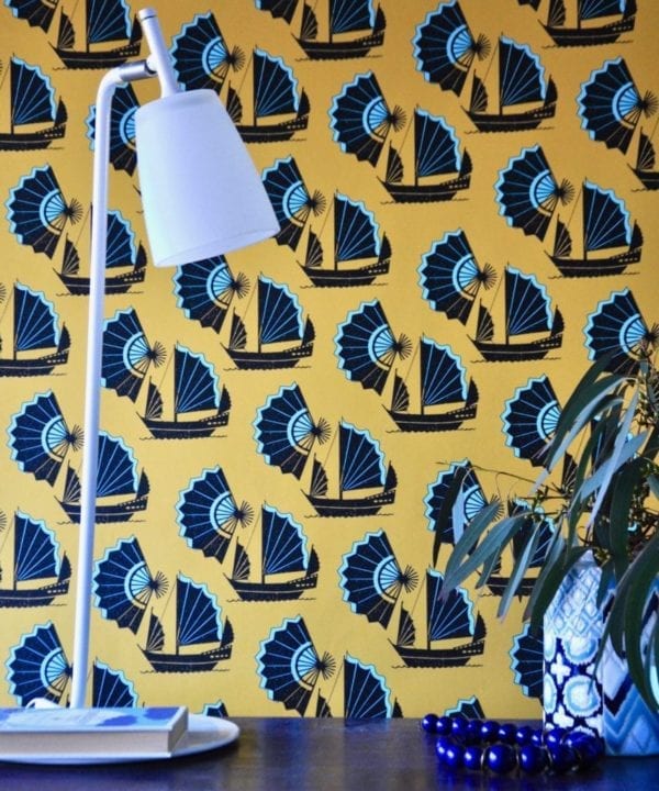 A bold yellow and turquoise wallpaper depicting Chinese junk ships and fans.