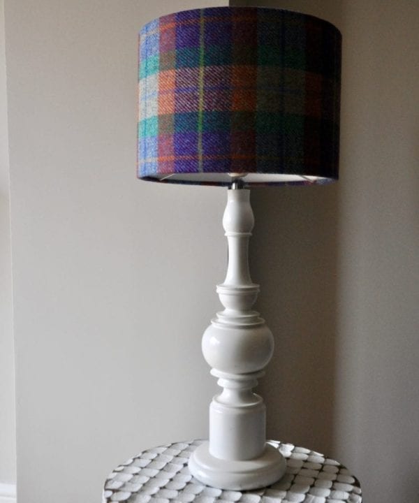 A colourful Harris tweed lampshade on a white, turned-wood lamp base.