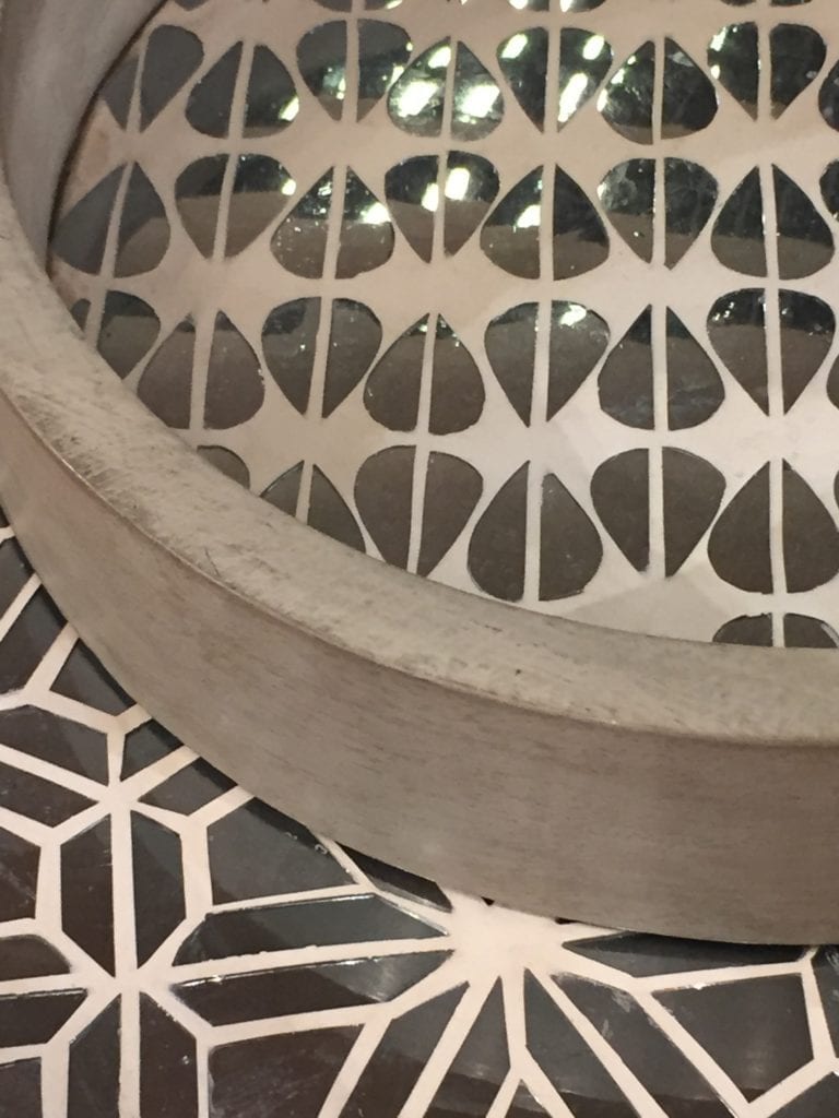 A mirror-mosaic and plaster circular tray against mirror mosaic furniture, both handmade in India.