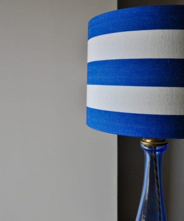 A shot of a stripy, drum lampshade in Royal blue and white.