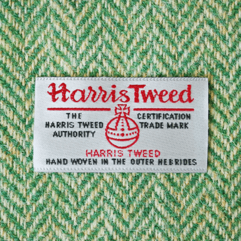 Close-up shot of Harris tweed orb label on green herringbone tweed.