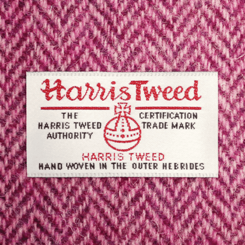 Close-up shot of Harris tweed orb label on pink herringbone tweed.