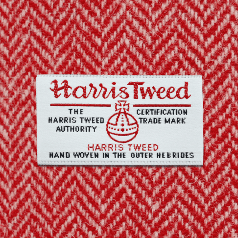 Close-up shot of Harris tweed orb label on red herringbone tweed.