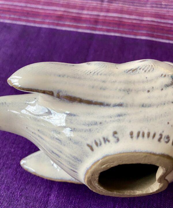 Reverse of bird sculpture with ceramicist's signature.