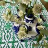 A blue and white small vase for the festive table in Dutch the tulipière style. Shown here on a green block print tablecloth filled with Astrantia.