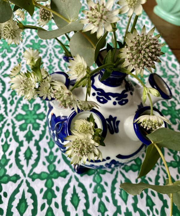 A blue and white small vase for the festive table in Dutch the tulipière style. Shown here on a green block print tablecloth filled with Astrantia.