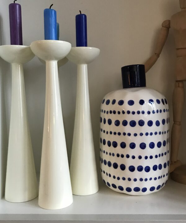 Snow white Danish candlesticks styled with blue and purple wax candles and a blue polka dot vase.