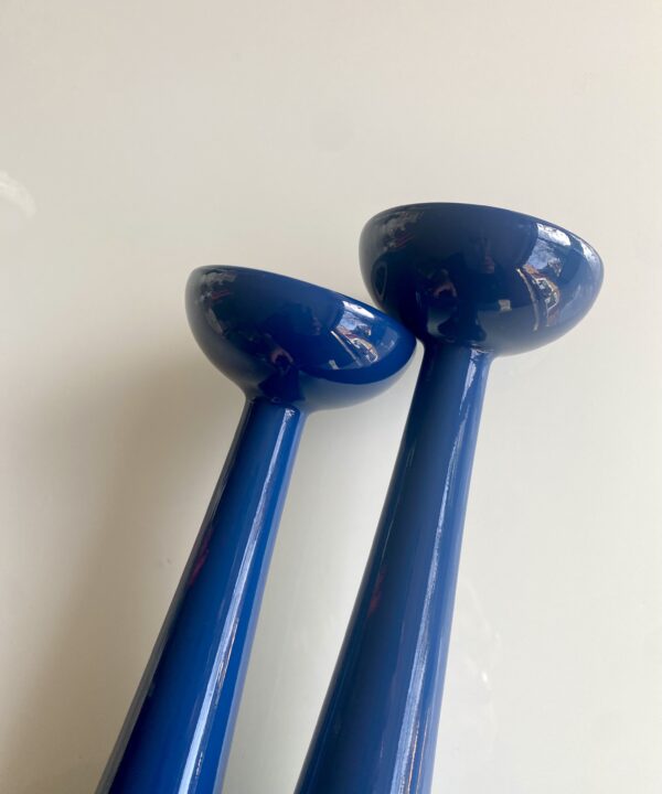 Blue candlesticks with a simple, Scandinavian design style silhouette.