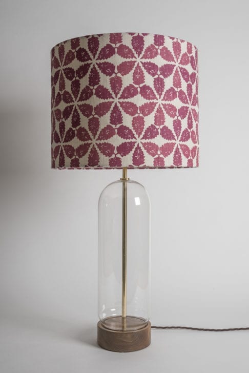 A clear glass lamp base with a Moroccan-print drum shade in red and cream.