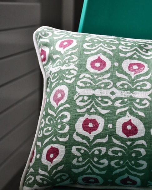 A green and red hand-print linen cushion with an Iznik design.