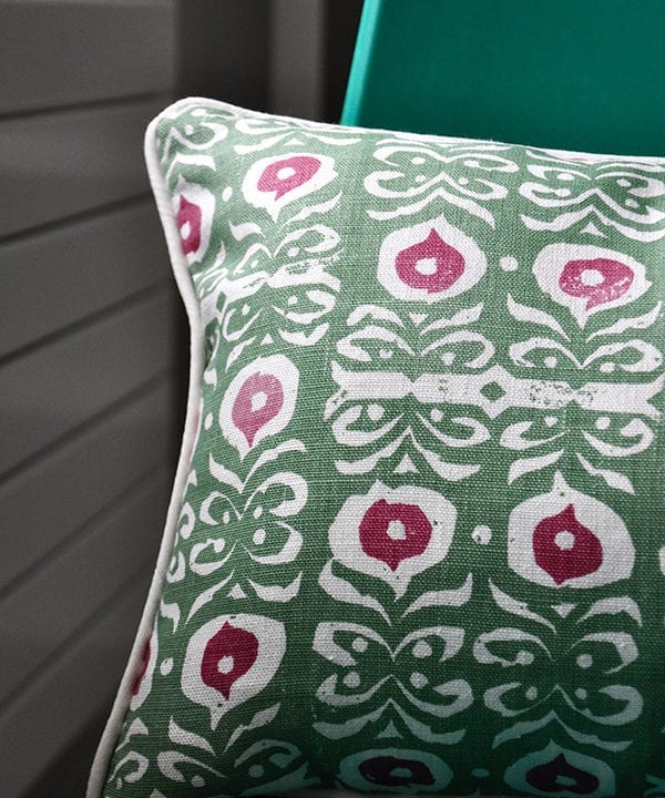 A green and red hand-print linen cushion with an Iznik design.