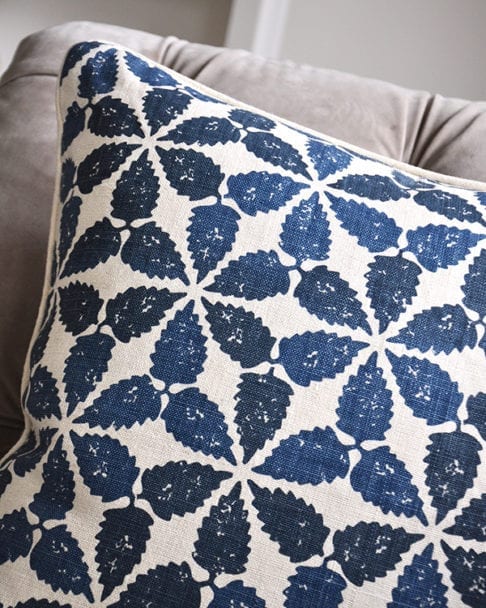 A close up shot of an indigo blue, hand-printed linen cushion with a Moroccan-inspired design.