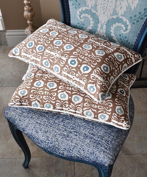 Brown, hand-print linen cushions on a blue chair in an Iznik design.