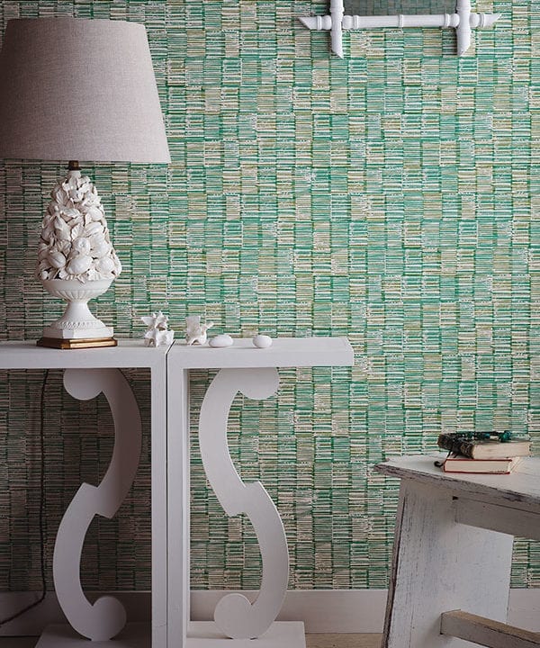 Japanese wallpaper in a verdant, green colourway styled with a white console and sculptural, ceramic lamp.