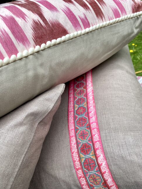 Detail of pink Ikat and vintage embroidery trimmed cushions.