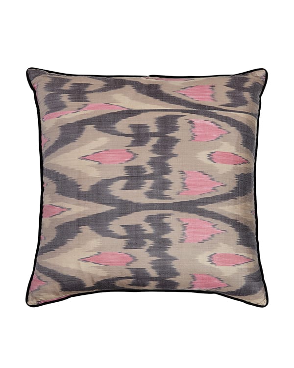 A cut out shot of pink, black and warm grey ikat cushions.