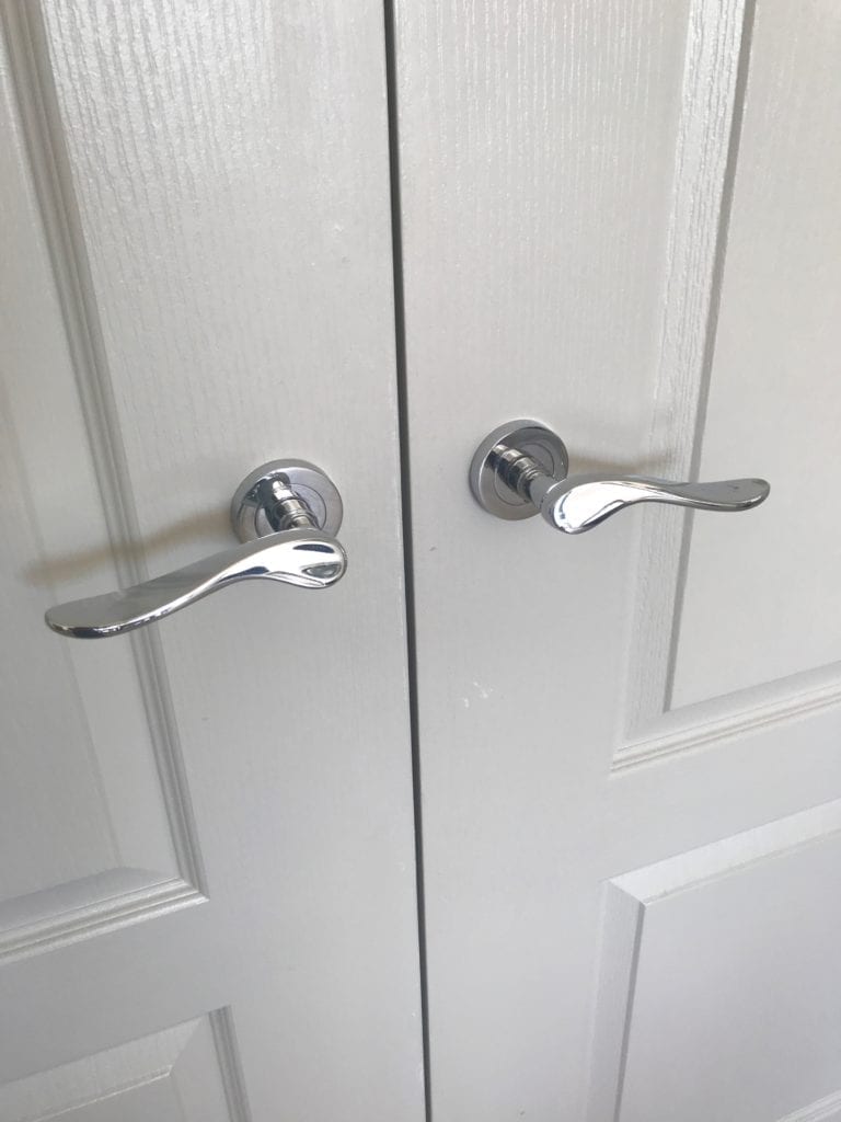 Pale, neutral paintwork on internal double doors with chrome handles.