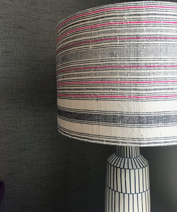 Black and white lampshade close up shot, with a pink stripe running through it in a slubby, vintage, Thai, handwoven hemp fabric.